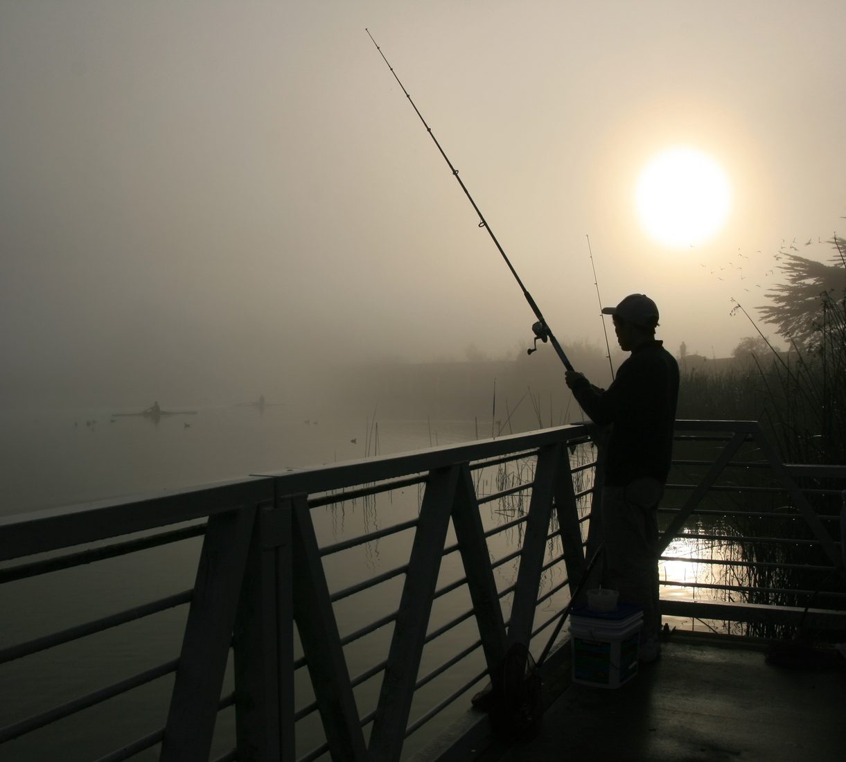 Angler on calm lake water